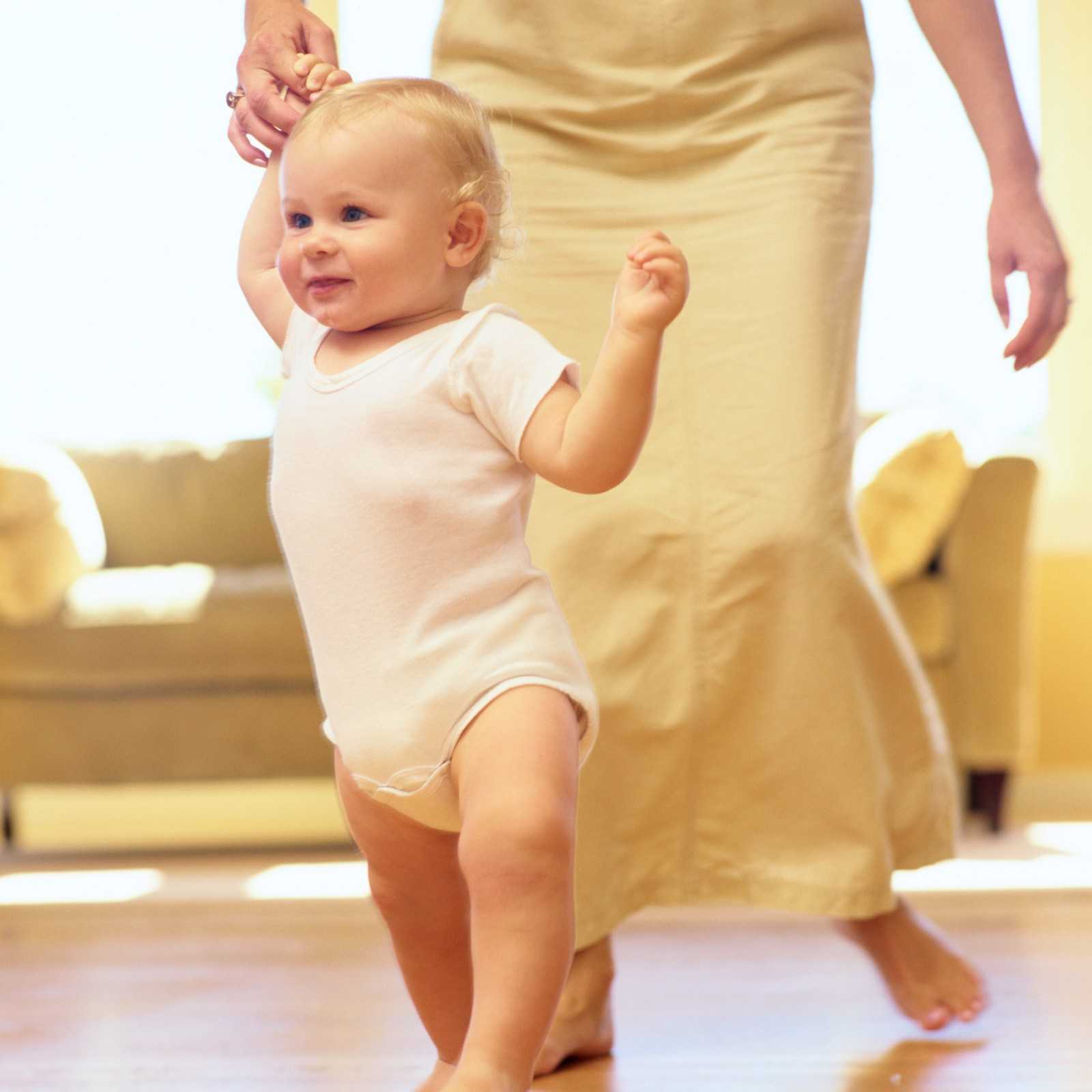 Когда ребенок начинает стоять на ножках: со скольки месяцев можно ставить придерживая